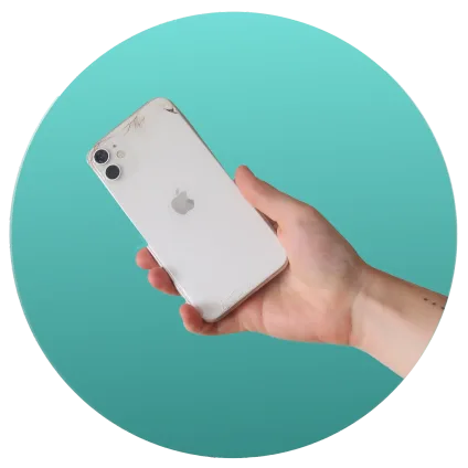 Hand holding a white iPhone with a cracked back